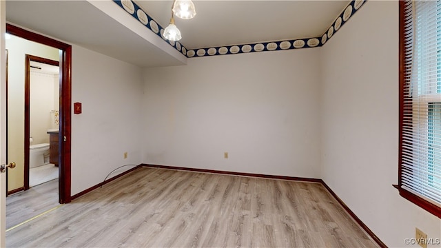 empty room with baseboards and light wood-style floors