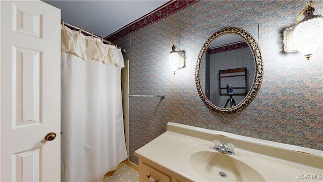 bathroom with wallpapered walls and vanity