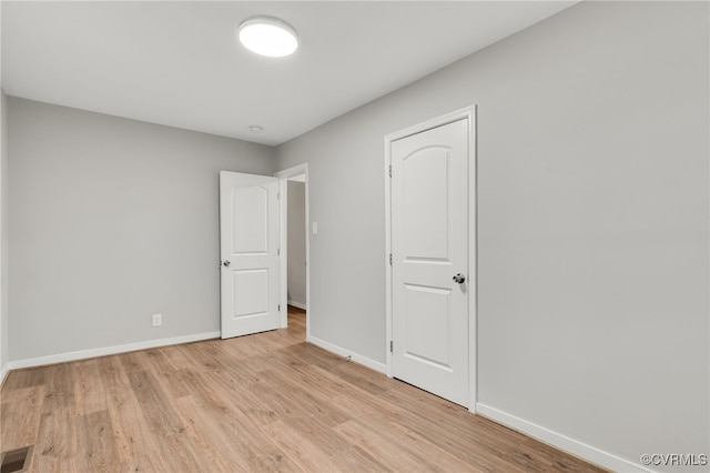 unfurnished bedroom with baseboards, visible vents, and light wood finished floors