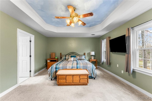 bedroom featuring a tray ceiling, multiple windows, baseboards, and carpet flooring