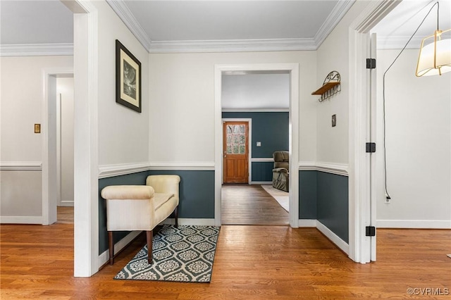 interior space featuring baseboards, wood finished floors, and ornamental molding