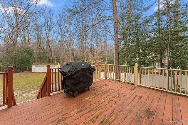 wooden deck with an outdoor structure, area for grilling, a storage unit, and a lawn