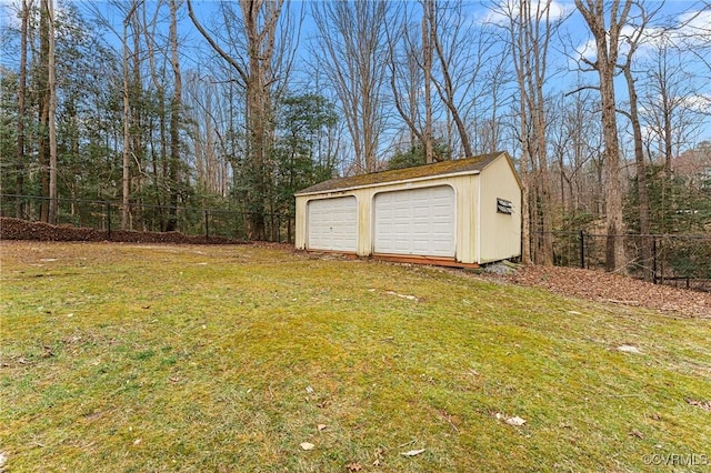 detached garage featuring fence