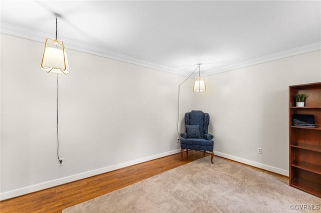 sitting room with baseboards, wood finished floors, and ornamental molding