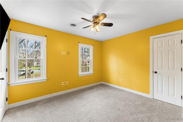 unfurnished room with baseboards, visible vents, carpet floors, and a healthy amount of sunlight