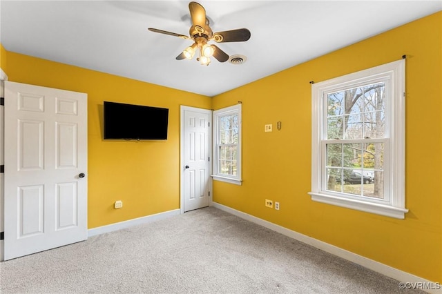 unfurnished bedroom with visible vents, baseboards, carpet, and a ceiling fan