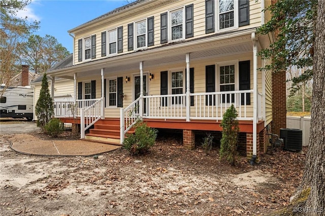 colonial inspired home with cooling unit and a porch