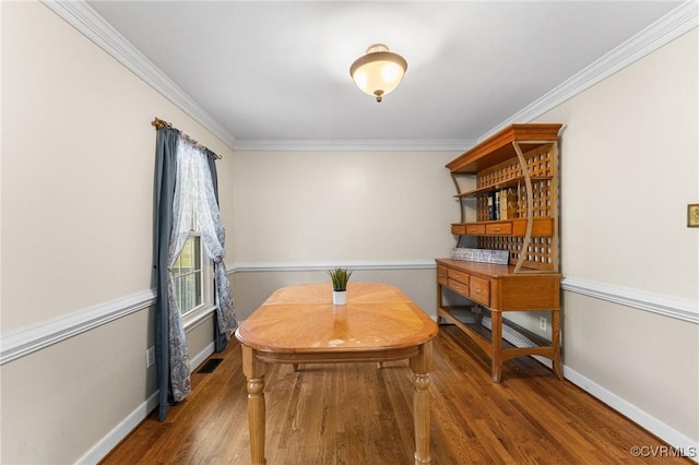 dining space featuring visible vents, wood finished floors, baseboards, and ornamental molding