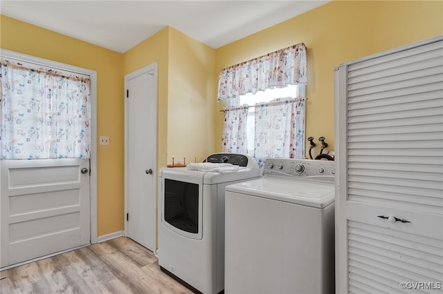 laundry room with laundry area, washer and dryer, and light wood-style flooring