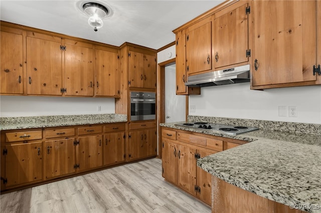 kitchen with under cabinet range hood, white electric stovetop, brown cabinetry, and stainless steel oven