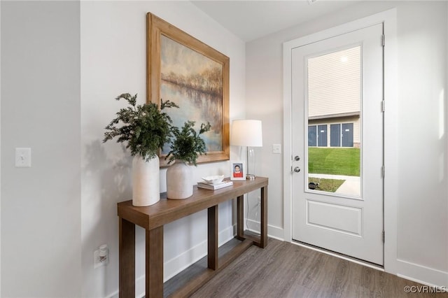 doorway featuring dark wood-style floors and baseboards