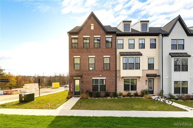 view of property featuring brick siding and a front lawn