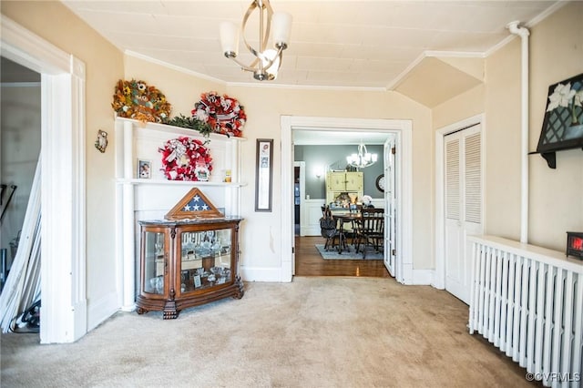 corridor featuring a chandelier, ornamental molding, and carpet flooring