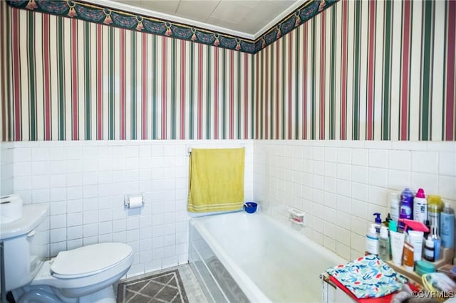 full bath with wainscoting, tile walls, and wallpapered walls