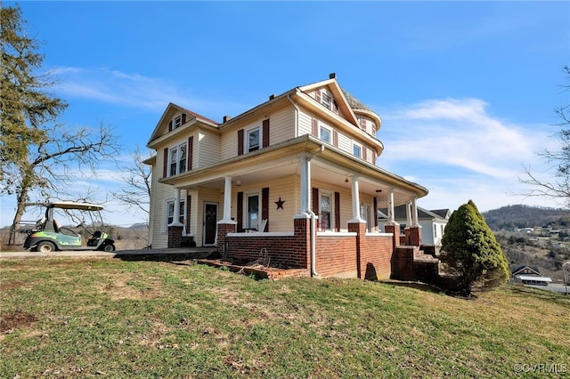 view of front of house with covered porch and a front yard