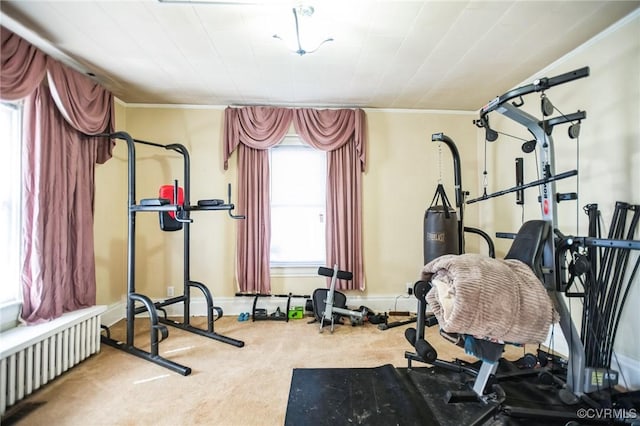 workout area with carpet floors, ornamental molding, radiator heating unit, and baseboards