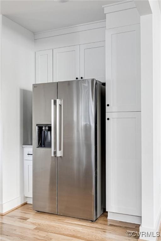 kitchen featuring high end fridge, white cabinets, light wood-style flooring, and baseboards