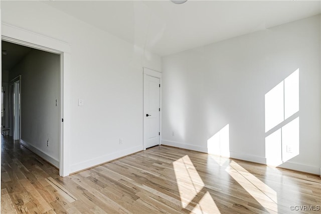 empty room with light wood-type flooring and baseboards