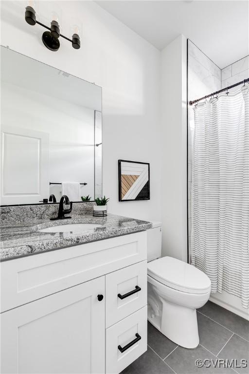 bathroom featuring curtained shower, vanity, toilet, and tile patterned floors