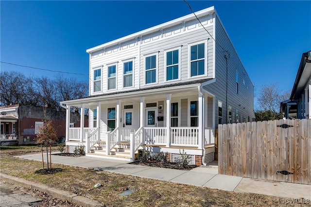 view of front facade featuring covered porch and fence