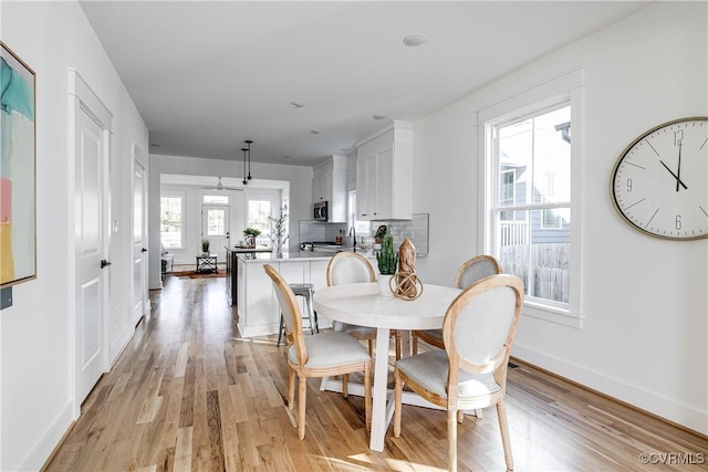 dining room featuring baseboards and light wood-style floors