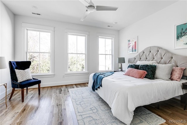 bedroom featuring light wood-style flooring, multiple windows, visible vents, and baseboards