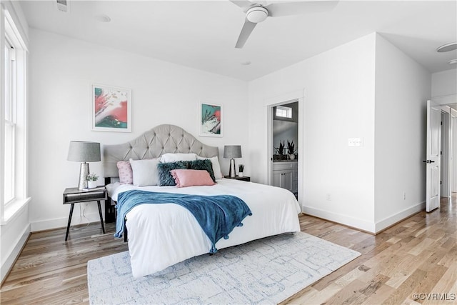 bedroom featuring light wood finished floors, connected bathroom, and baseboards