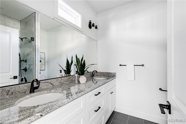 bathroom featuring double vanity, a sink, a shower stall, and tile patterned floors