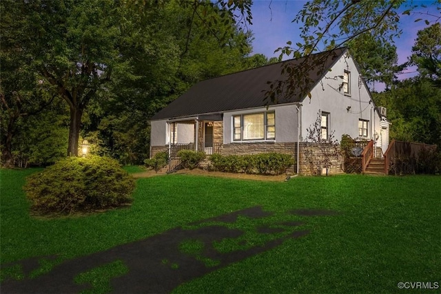 view of front of property with stone siding, a lawn, and stucco siding