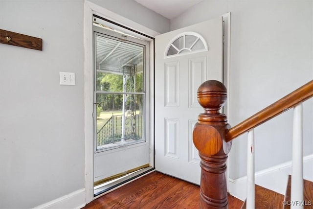 doorway with stairs, baseboards, and dark wood-style flooring