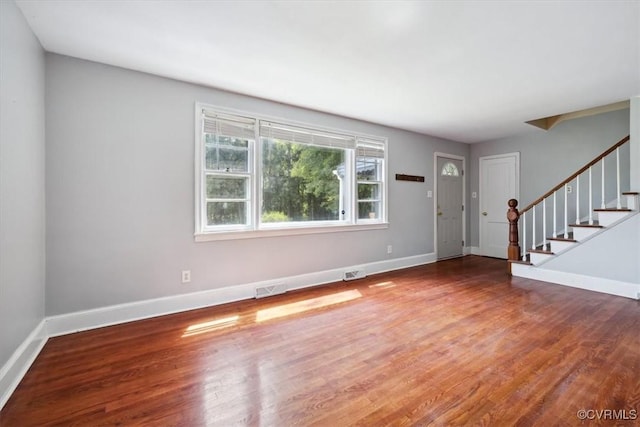 foyer entrance featuring stairway, wood finished floors, and baseboards