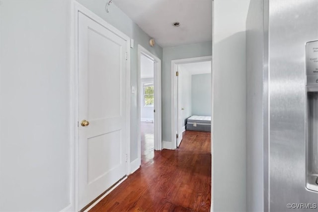 hall featuring baseboards and dark wood-style flooring