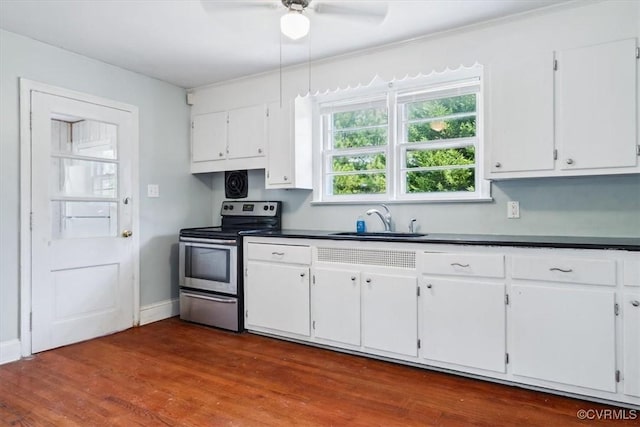 kitchen featuring a sink, stainless steel range with electric stovetop, and white cabinets