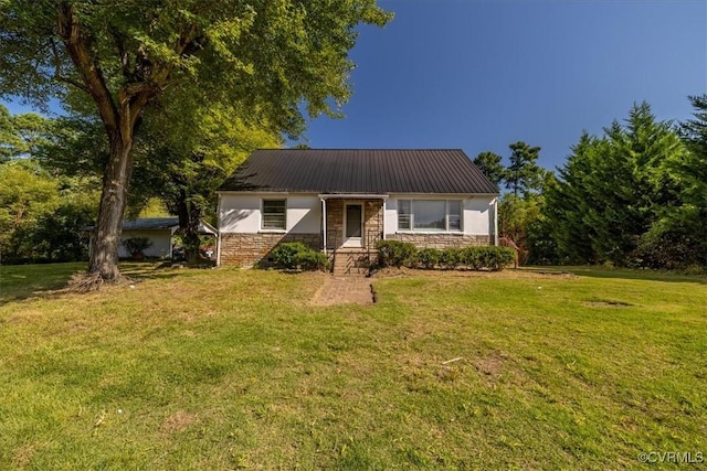 view of front of home with stone siding, stucco siding, metal roof, and a front lawn