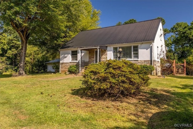 view of front of property with stone siding, stucco siding, metal roof, and a front lawn