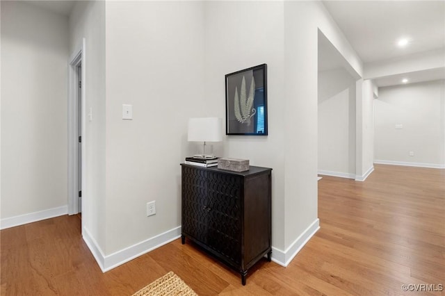 corridor with recessed lighting, baseboards, and light wood-type flooring