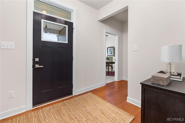 foyer featuring baseboards and wood finished floors