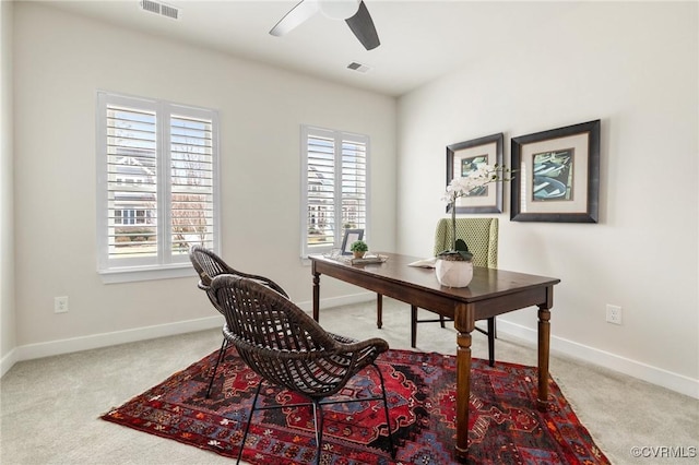 office space featuring visible vents, a healthy amount of sunlight, a ceiling fan, and carpet floors