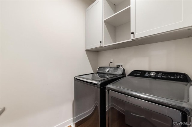 washroom featuring cabinet space and separate washer and dryer