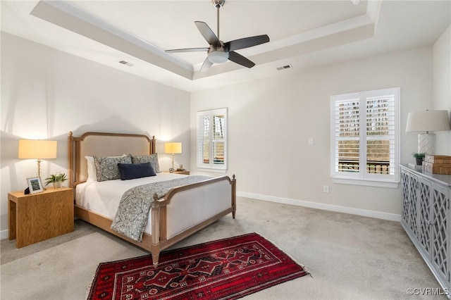 bedroom featuring visible vents, baseboards, carpet, and a tray ceiling