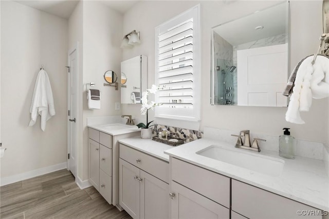 full bath with a sink, baseboards, walk in shower, and wood finished floors