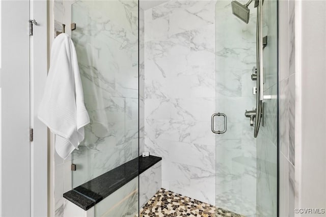 bathroom featuring a marble finish shower