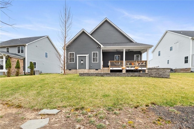 rear view of property featuring crawl space, a yard, and a ceiling fan