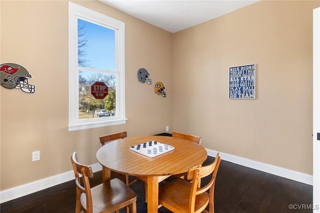 dining space featuring dark wood-type flooring and baseboards