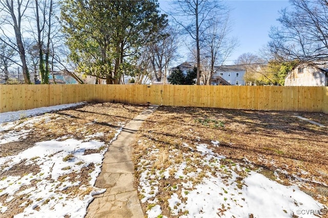 yard covered in snow featuring fence