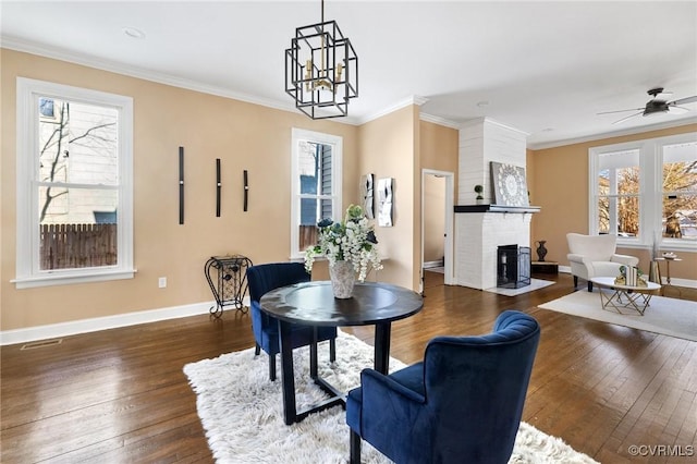 dining space with baseboards, dark wood-type flooring, a fireplace, and crown molding