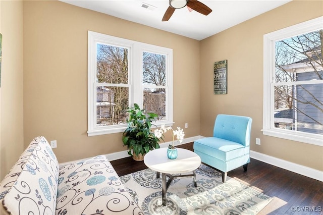 living area featuring dark wood-style floors, visible vents, ceiling fan, and baseboards