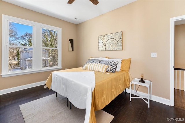 bedroom with dark wood-style flooring, visible vents, and baseboards