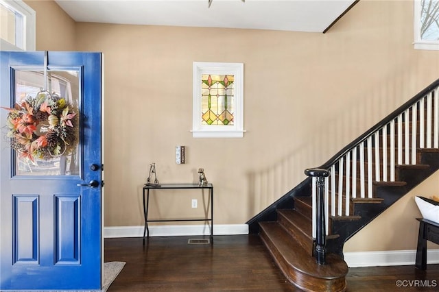 foyer entrance with stairway, wood finished floors, visible vents, and baseboards