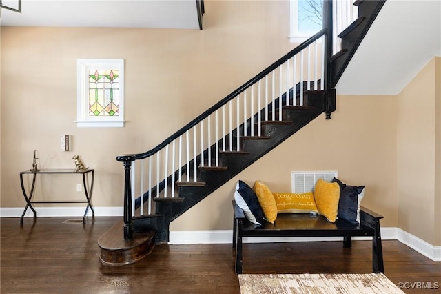 stairs with visible vents, baseboards, and wood finished floors